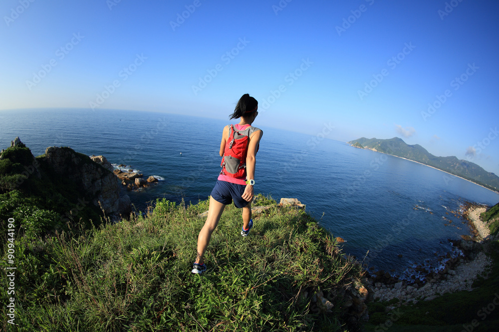 young fitness woman trail runner running on seaside mountain