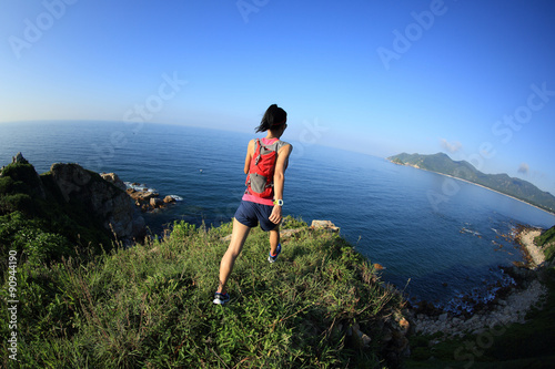 young fitness woman trail runner running on seaside mountain