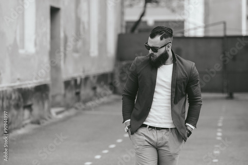 Stylish bearded man walks through the city © teksomolika