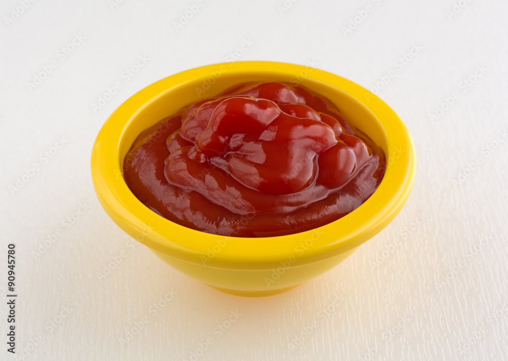 Ketchup in a small yellow bowl Ketchup in a small yellow bowl
