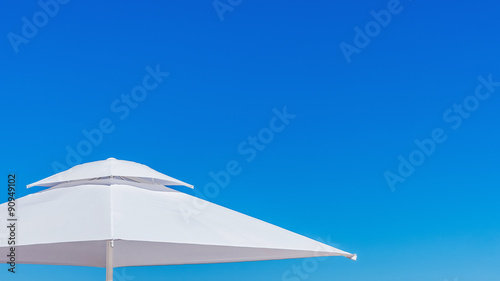 White beach umbrella at the clean blue sky.