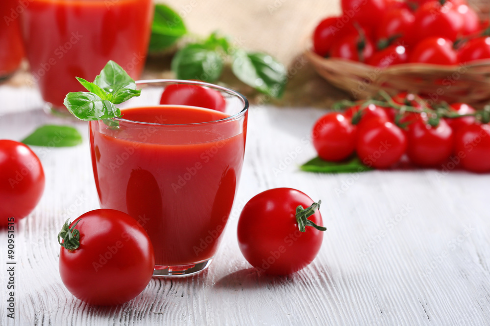 Glass of tomato juice on wooden table, closeup