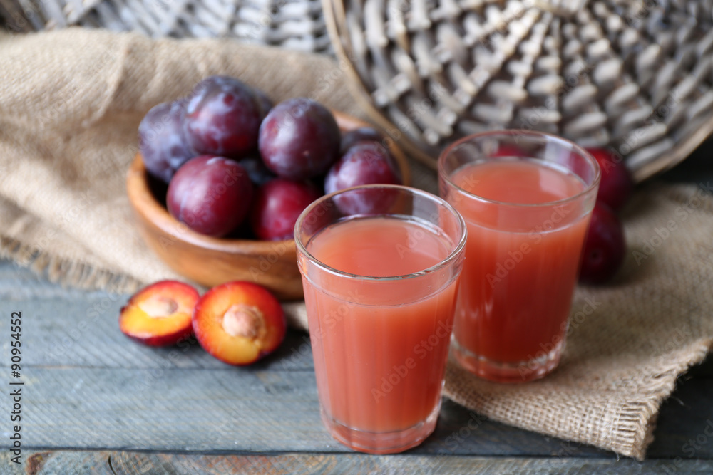 Delicious plum juice with fruits on wooden table close up Delicious plum juice with fruits on wooden table close up