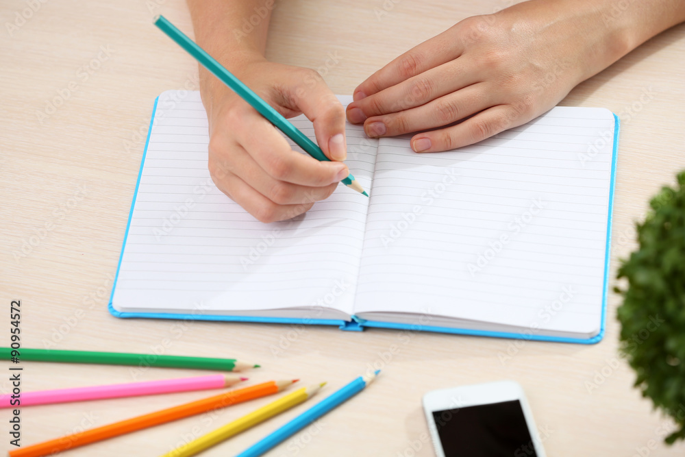 Woman write on notebook on workplace close up Woman write on notebook on workplace close up