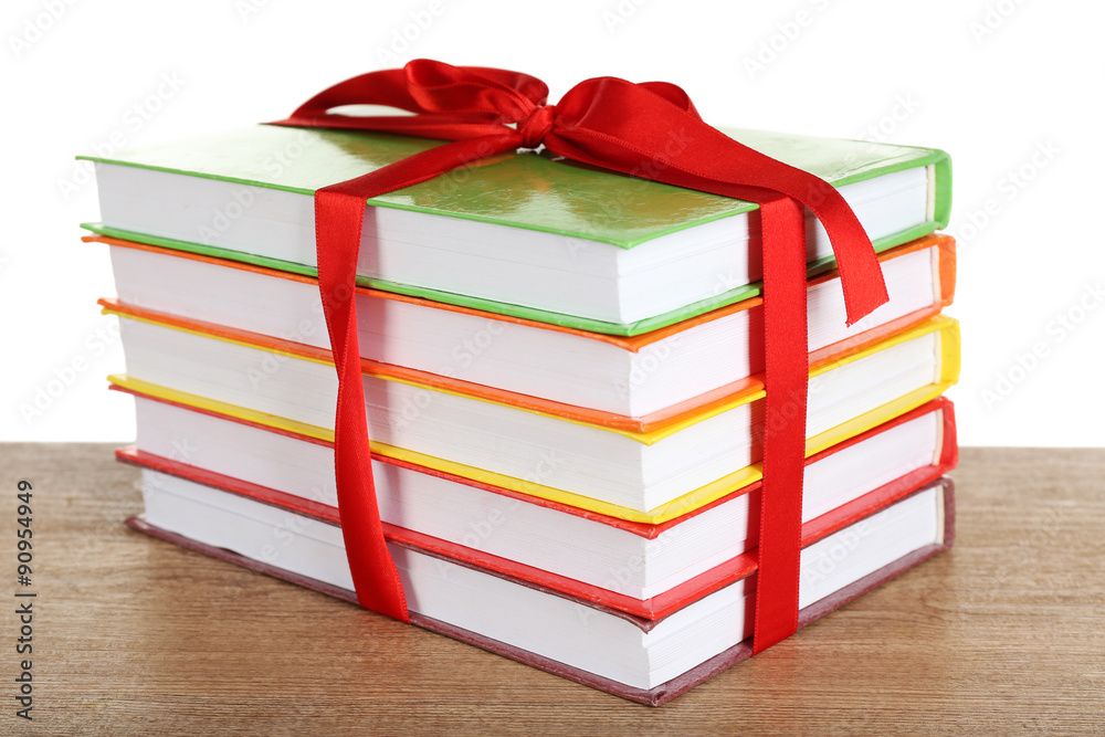 Fototapeta premium Stack of books with ribbon on light background
