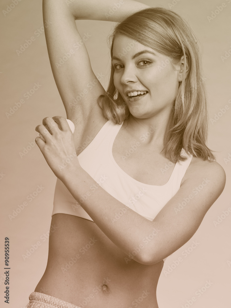 Fototapeta premium Girl applying stick deodorant in armpit.