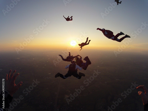Skydiving group of people at the sunset