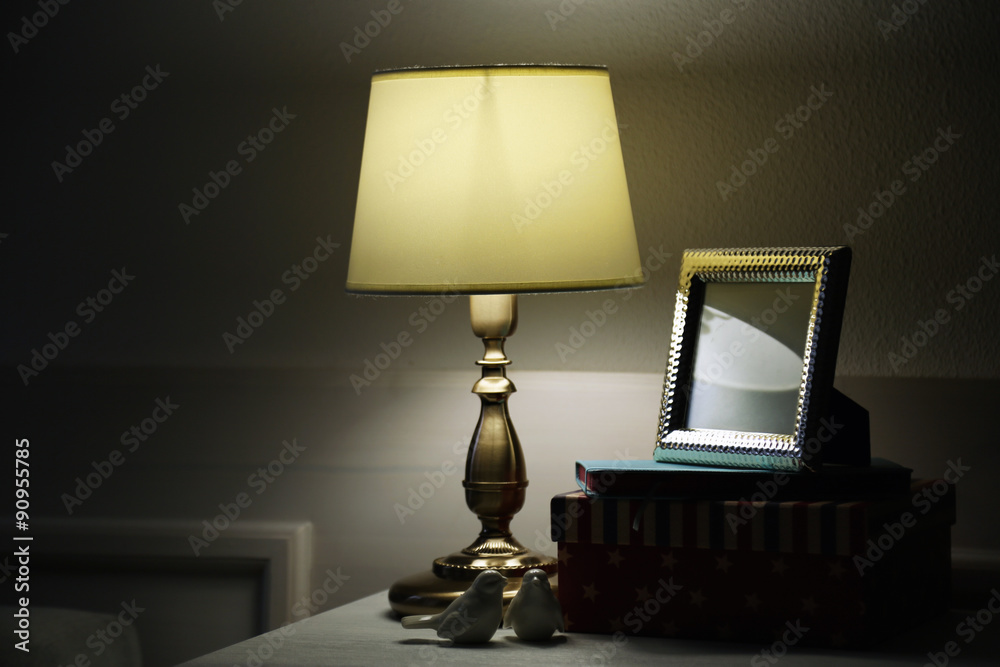 Old fashion table lamp on nightstand on wall background Old fashion table lamp on nightstand on wall background
