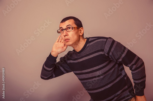 European-looking man of 30 years with glasses, overhears retro photo