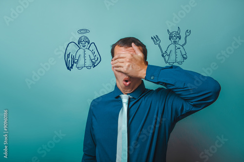 man Male businessman closed his eyes, his hands angel devil demo photo
