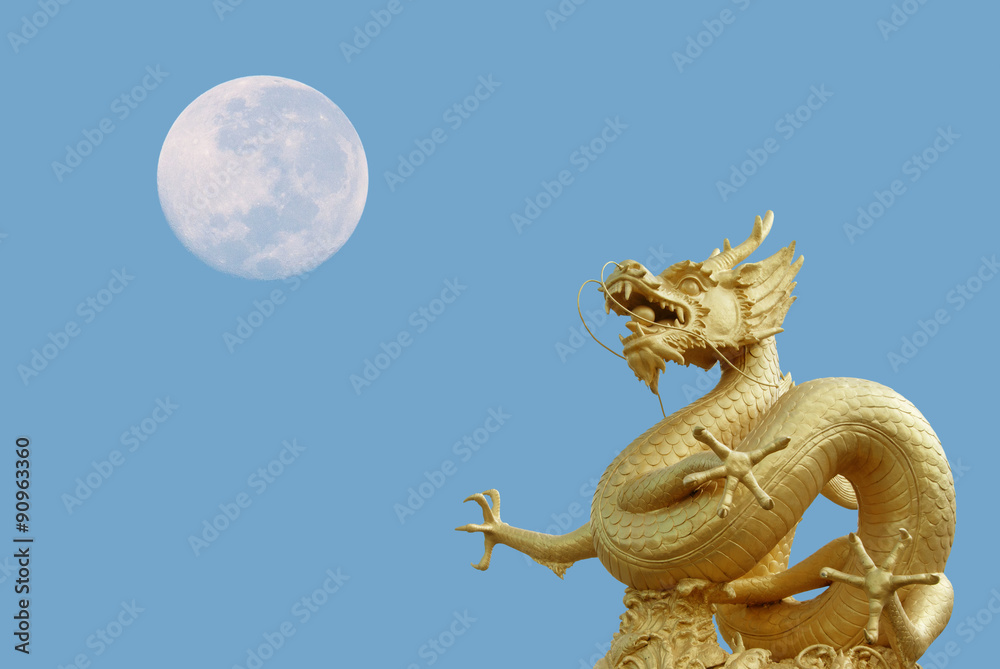 Naklejka premium golden dragon statue and moon at isolated on blue sky background