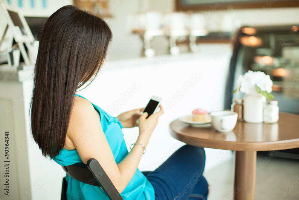 Young brunette texting in a cafe Young brunette texting in a cafe