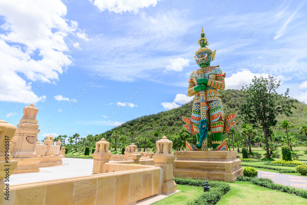 Ancient statue of giant guardian at public park with mountain background.
