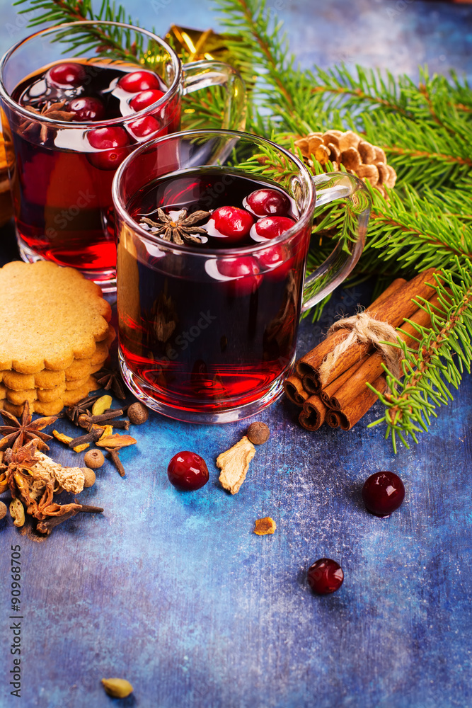 Hot xmas mulled wine with spices and cranberry in glass cups. Christmas or new year decorations. Selective focus Hot xmas mulled wine with spices and cranberry in glass cups. Christmas or new year decorations. Selective focus