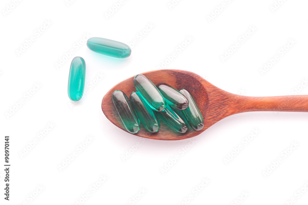 Pills capsule on wooden spoon isolated Pills capsule on wooden spoon isolated