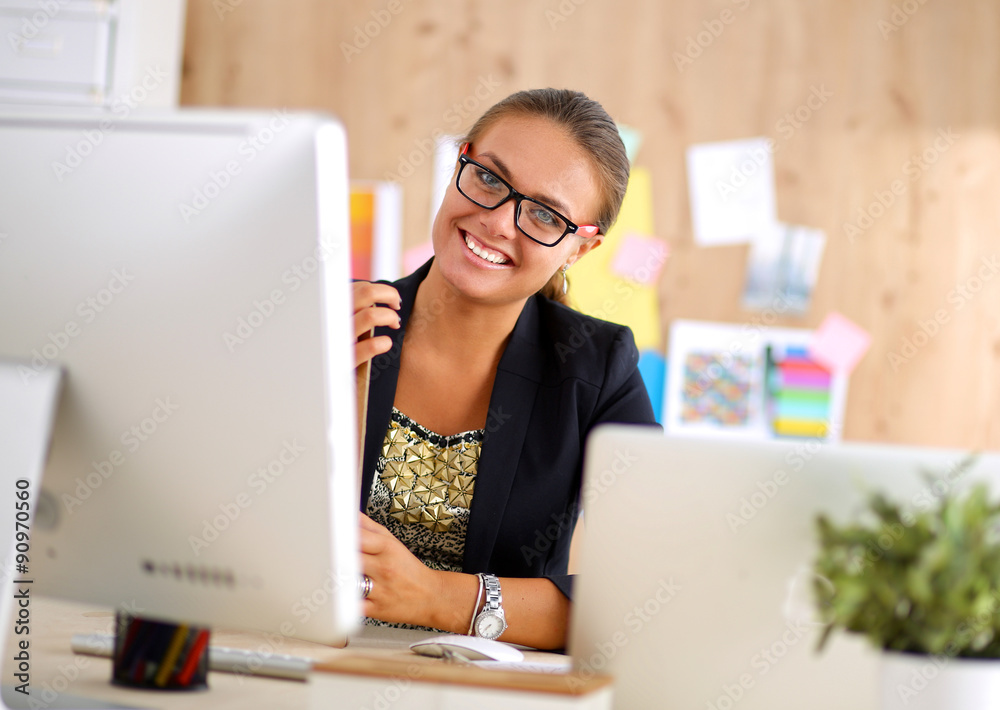 Fashion designers working in studio sitting on the desk Fashion designers working in studio sitting on the desk