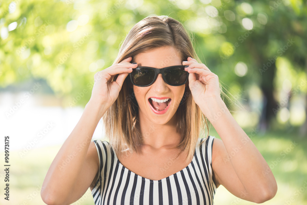 Summer portrait, young brunette woman playing with her sunglasses and having fun outdoor Summer portrait, young brunette woman playing with her sunglasses and having fun outdoor