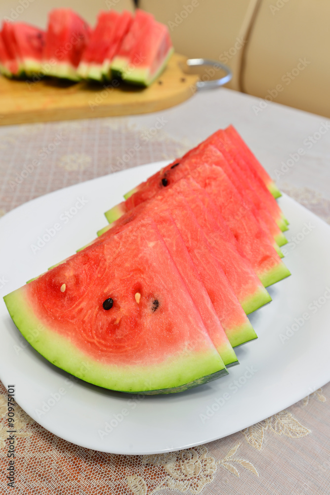 slices of watermelon on a plate at the table slices of watermelon on a plate at the table