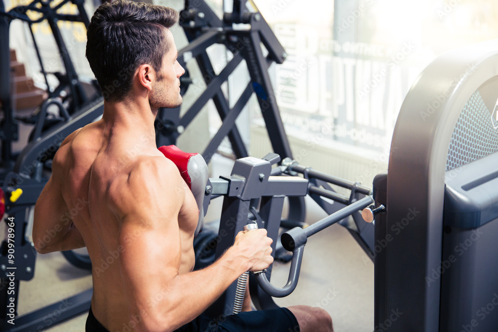 Man workout on fitness machine at gym Man workout on fitness machine at gym