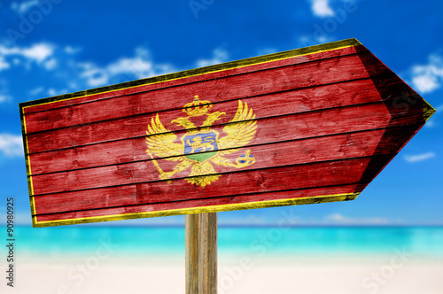 Montenegro Flag wooden sign on beach background photo