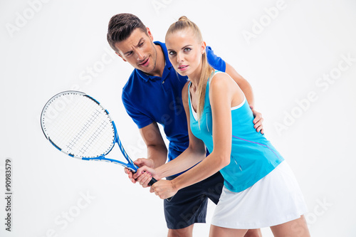 Portrait of a man training woman to playing in tennis