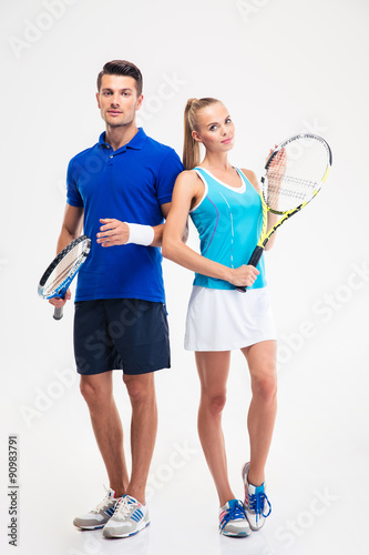 Sports couple standing with tennis racket