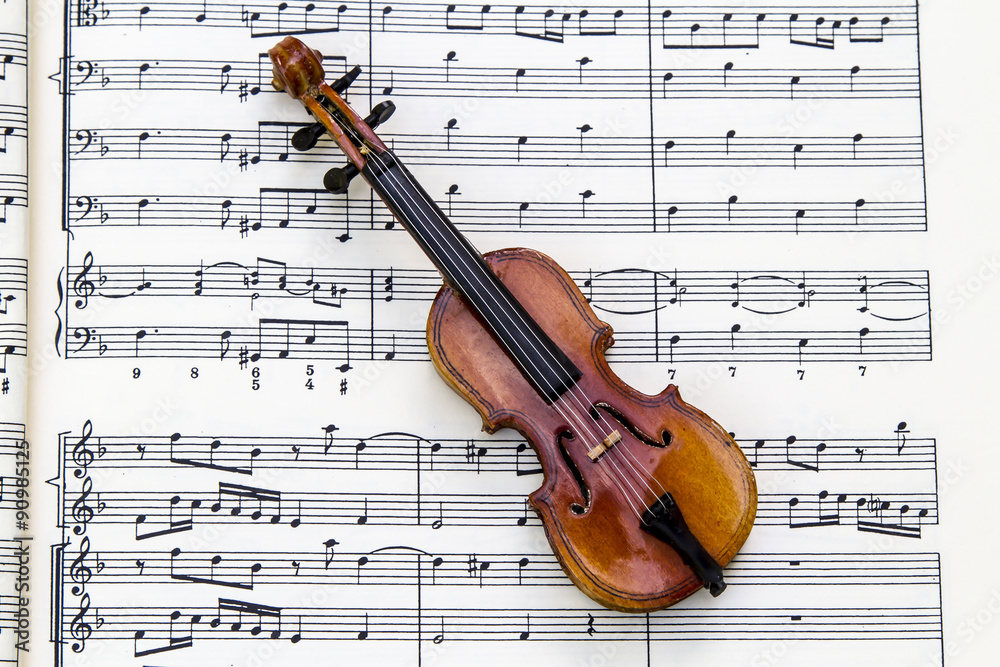 Naklejka premium Violín sobre pentagramas