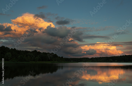 beautiful sky on a sunset over the forest lake