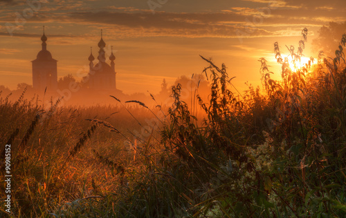 Silhouette of church in morning fog at sunrise photo