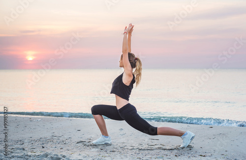  Fitness sport model smiling happy doing exercises during outdoor work out on sunrise. Beautiful caucasian female training outside on seaside in the morning