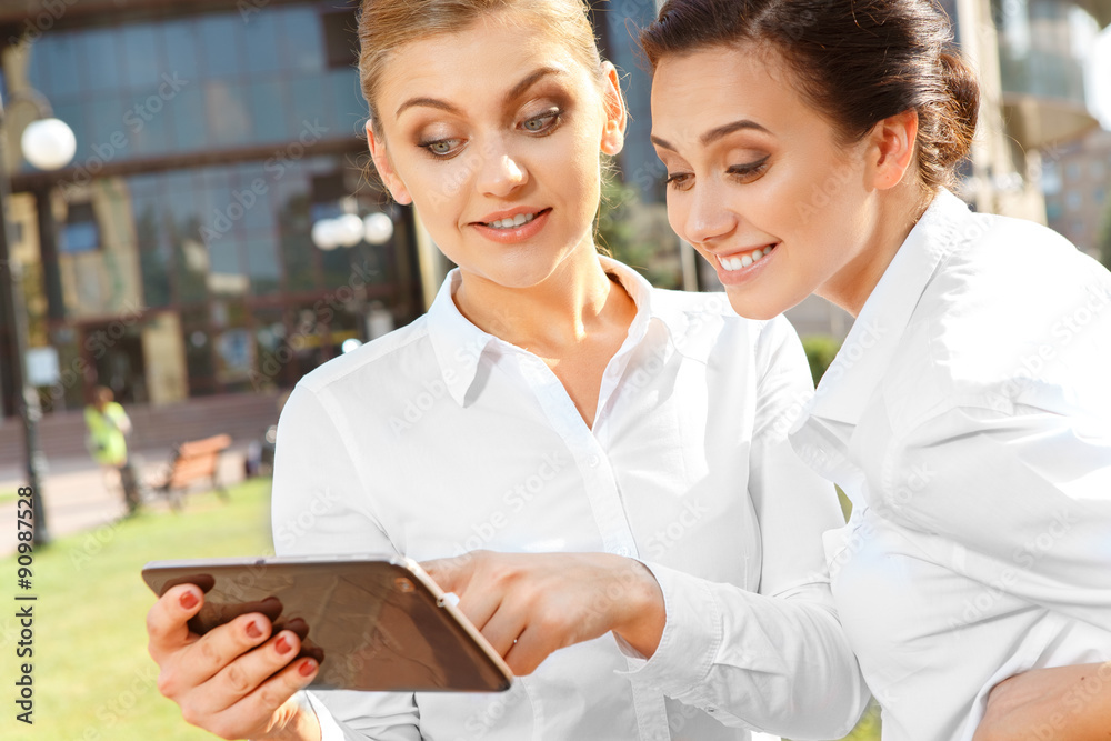Obraz premium Two businesswoman with a tablet