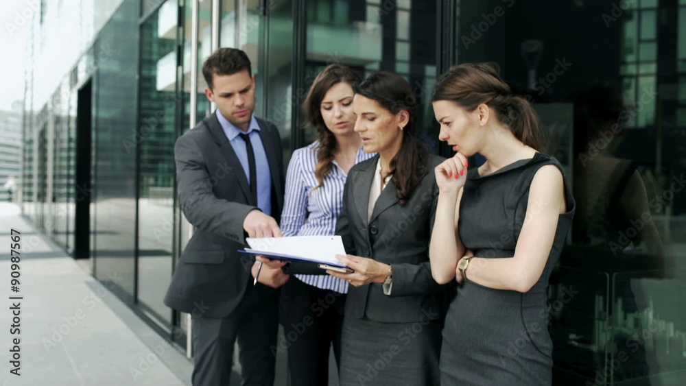 Businesspeople discussing documents outside the building, steadycam shot
Businesspeople discussing documents outside the building, steadycam shot