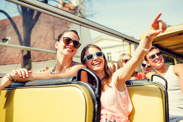 group of smiling friends traveling by tour bus