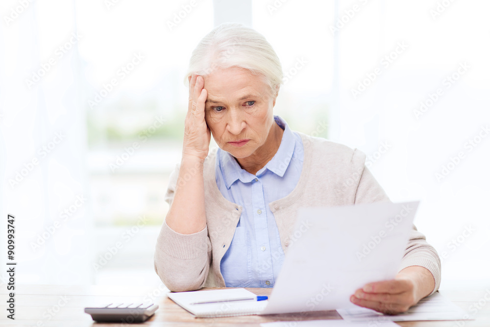 senior woman with papers and calculator at home senior woman with papers and calculator at home