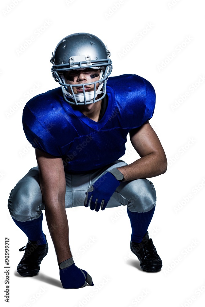 American football player in uniform crouching