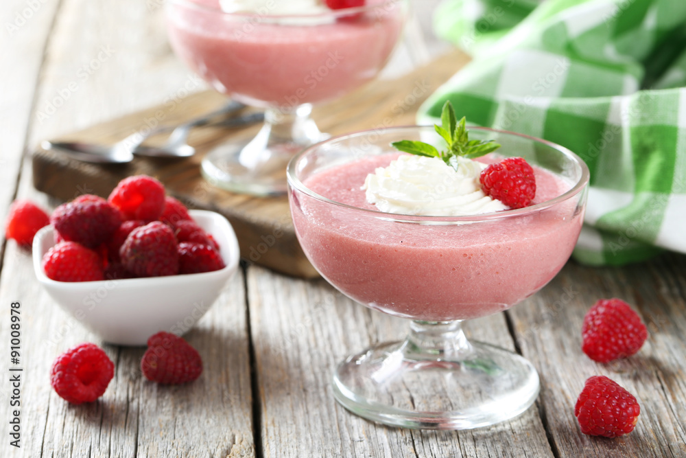 Sweet raspberry mousse in glass on grey wooden table Sweet raspberry mousse in glass on grey wooden table