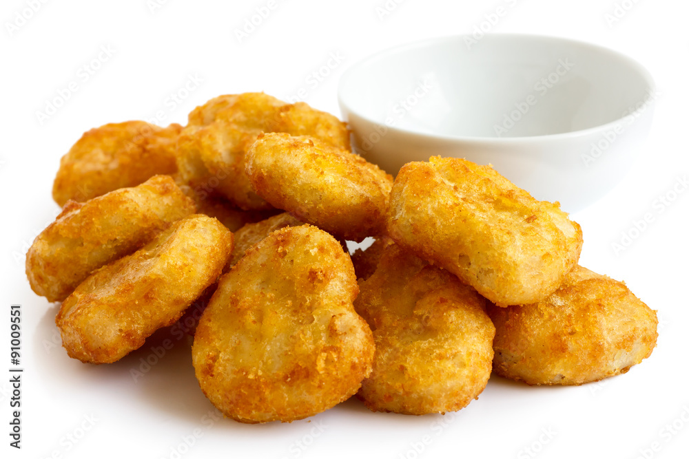 Pile of golden deep-fried battered chicken nuggets with empty bo