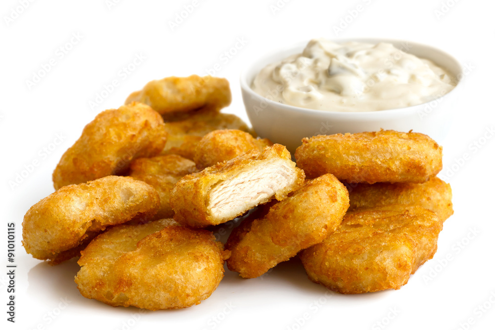 Pile of golden deep-fried battered chicken nuggets with bowl of Pile of golden deep-fried battered chicken nuggets with bowl of