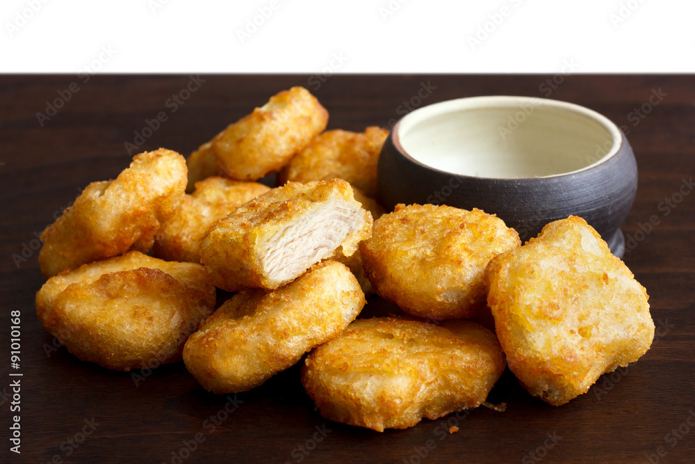 Pile of golden deep-fried battered chicken nuggets with empty ru Pile of golden deep-fried battered chicken nuggets with empty ru