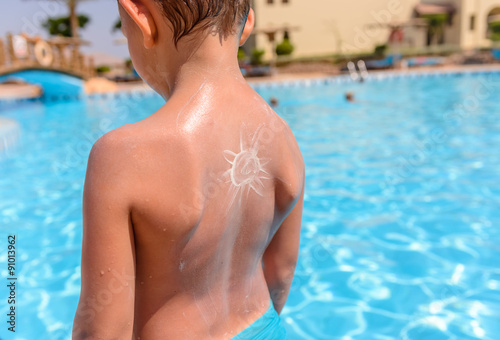 Young boy with a sunscreen sun on his back