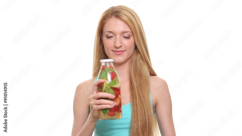 Close up of slim woman with fruit detox water in glass bottle on white background. Close up of slim woman with fruit detox water in glass bottle on white background.