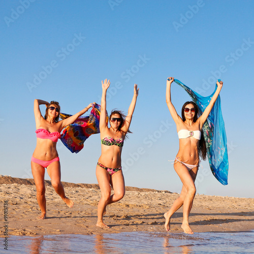 Group of girls jumping on the beach