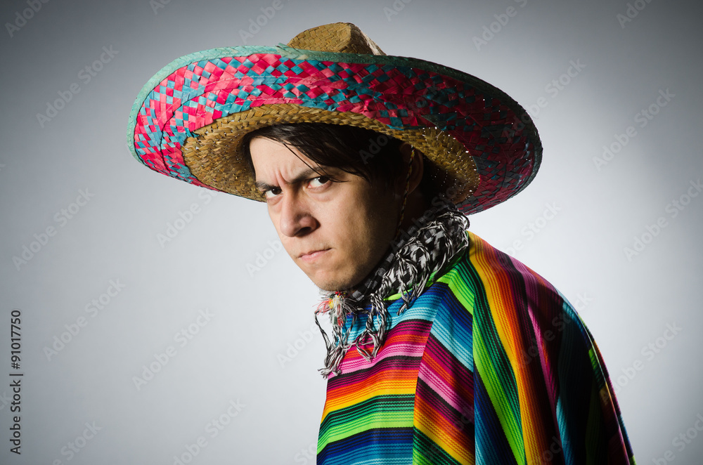 Man in vivid mexican poncho against gray