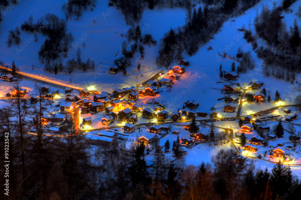 Fototapeta premium Night view of the mountain village of Vissoie, canton of Valais, Switzerland, taken from uphill at the village of St Luc
