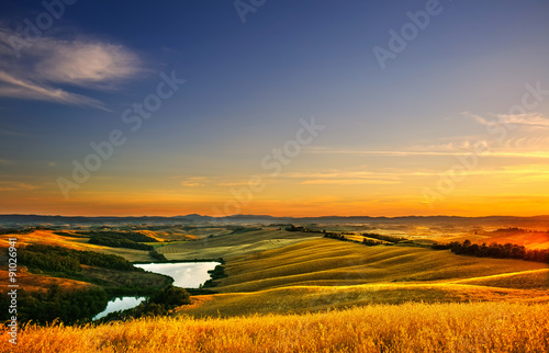 Tuscany  rural landscape on sunset  Italy. Lake and green fields