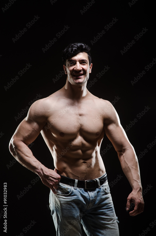 Fototapeta premium Muscular man posing in dark studio