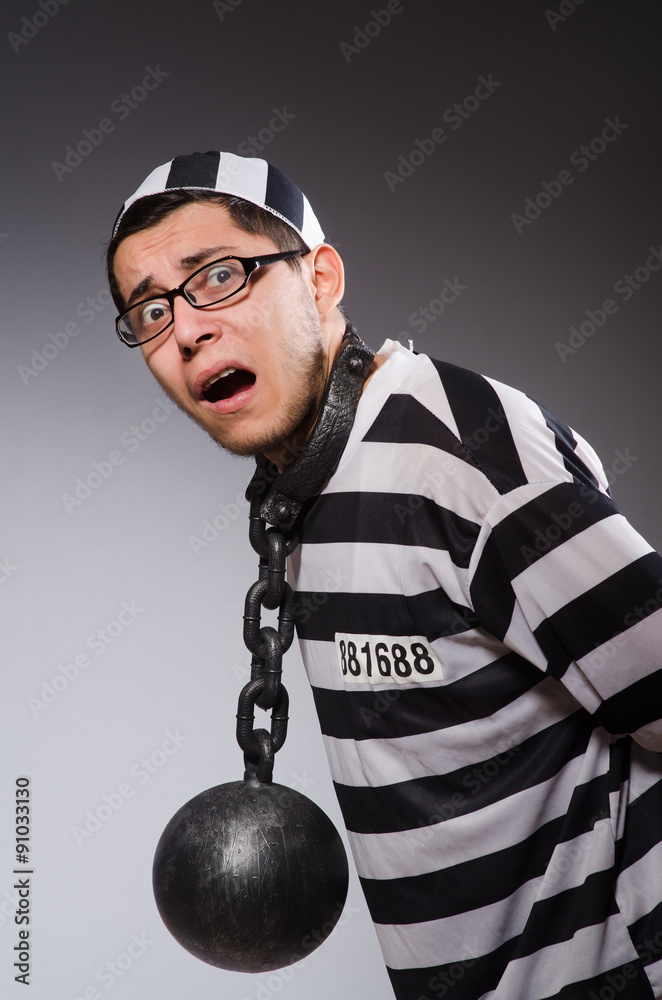 Young prisoner in chains against gray Young prisoner in chains against gray