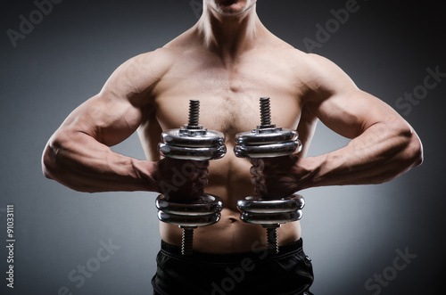 Muscular ripped bodybuilder with dumbbells