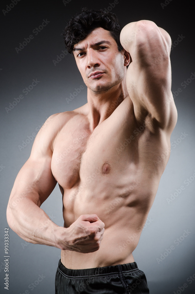 Obraz premium Muscular man posing in dark studio