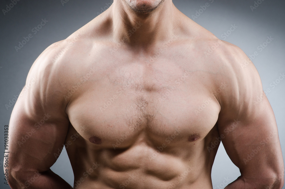 Fototapeta premium Muscular man posing in dark studio